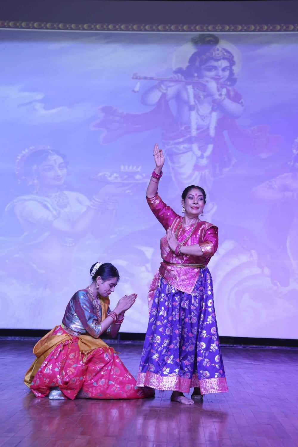 A teacher correcting a student's posture during a Kathak class